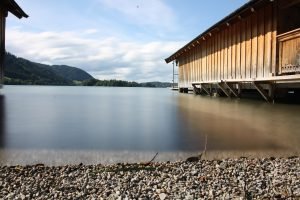 schliersee, boathouse, woodhouse, beach, pebbles, lake, waves, long exposure, water, bavaria, germany, mountains, forest, blue sky, weather, sunshine, summer, spring, scenic, background, southern bavaria, holiday home, fishermans house, rental, rent